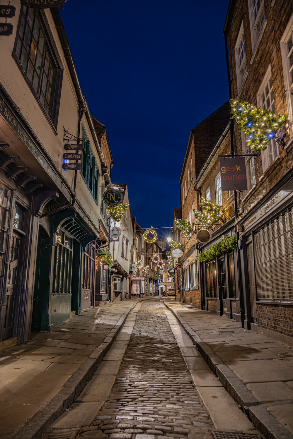 a cobblestone street in a small town at night