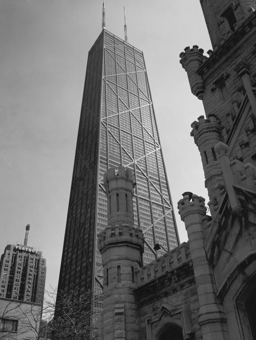 John Hancock Center Summary Photograph shows John Hancock Center designed by Bruce Graham for Skidmore, Owings & Merrill framed by old Water Tower, Chicago, Illinois