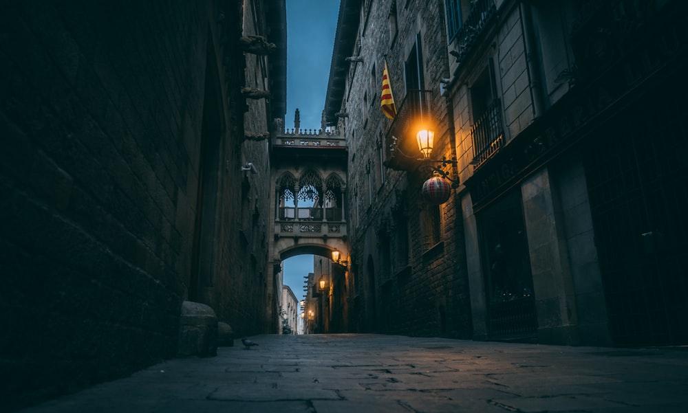 a narrow alley way with a light on at night