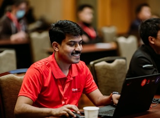 A person happily using a laptop to create a cricket betting ID on reddyanna's platform.