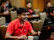 Smiling young Indian man sitting at desk with laptop, taking notes during online SAP training.