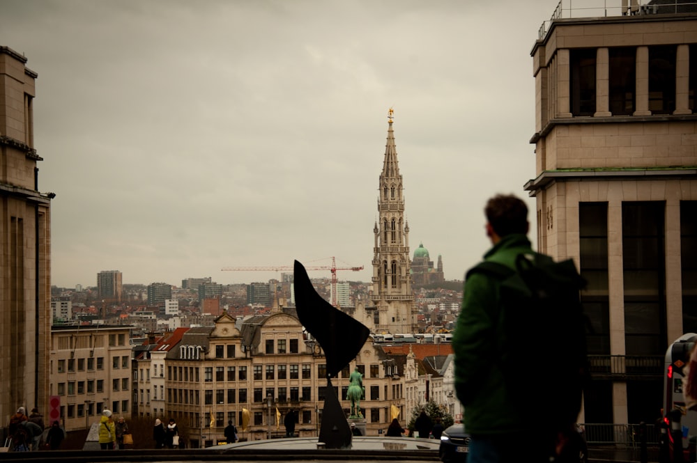 a man standing on top of a roof next to tall buildings