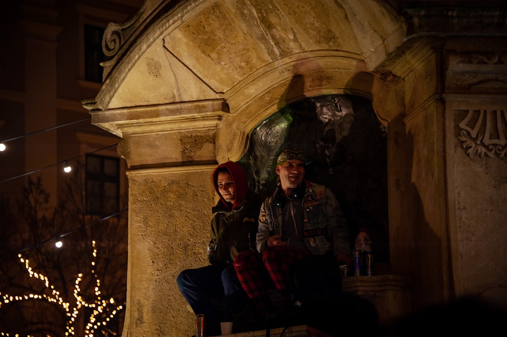 a man and a woman sitting on a bench at night