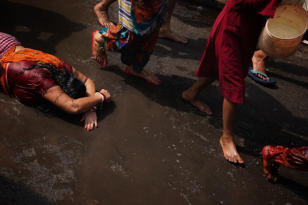 a woman laying on the ground in front of a group of people