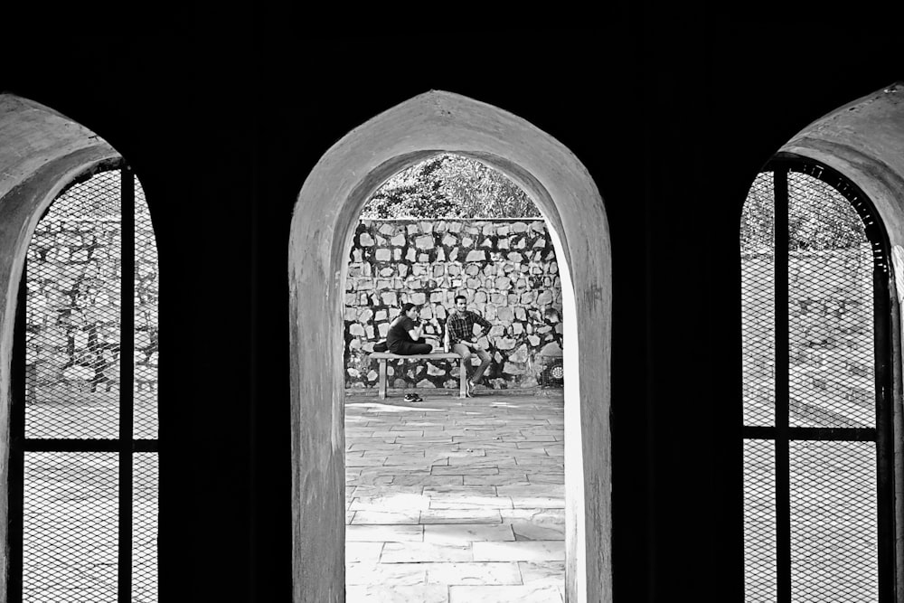 a black and white photo of two arched windows