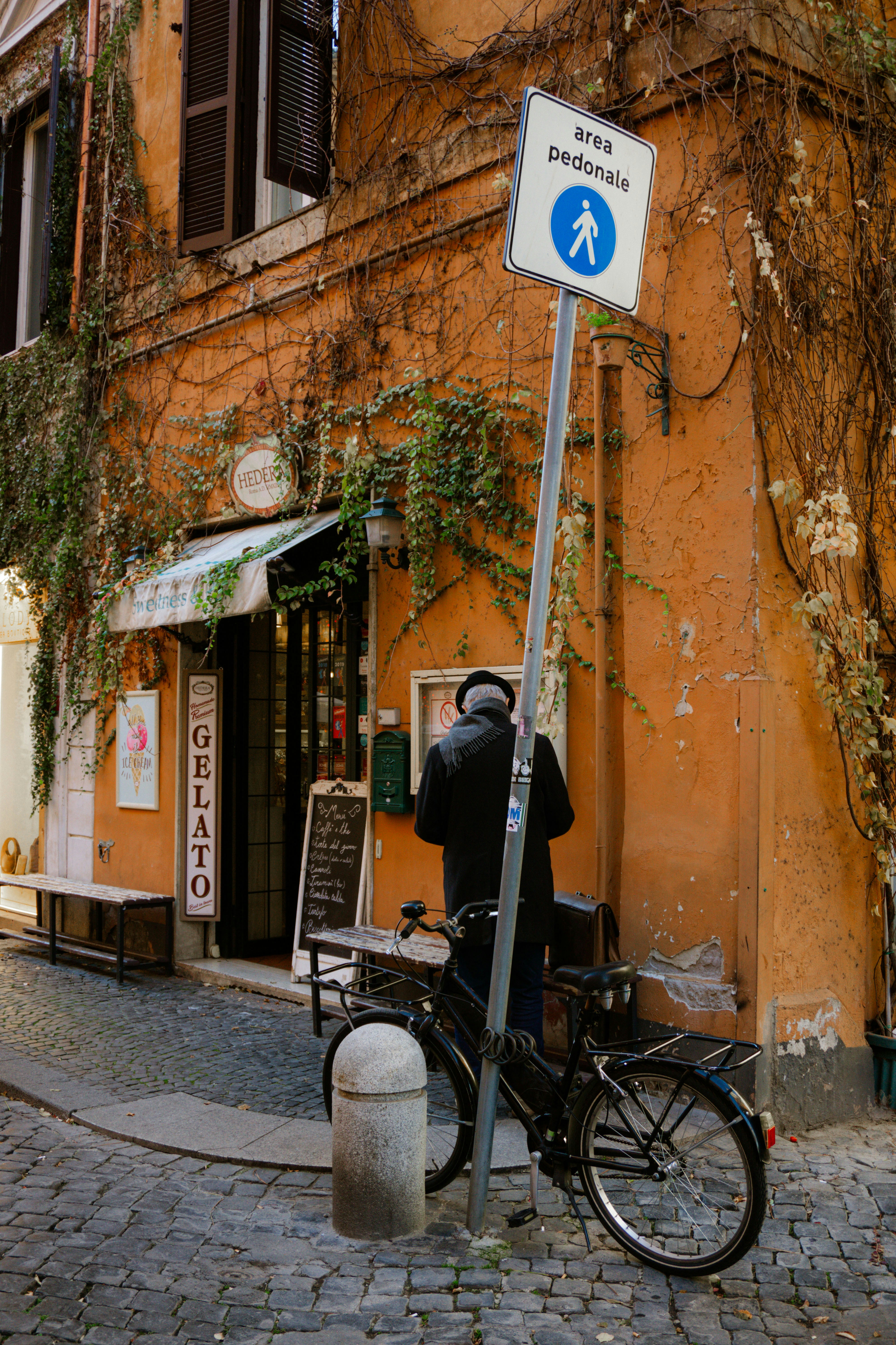 un uomo in piedi accanto a una bicicletta su una strada di ciottoli