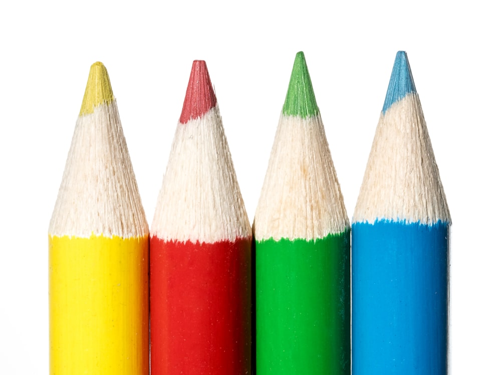 a row of colored pencils sitting next to each other