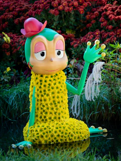 A charming strawberry frog sitting among lush green leaves with a dreamy atmosphere