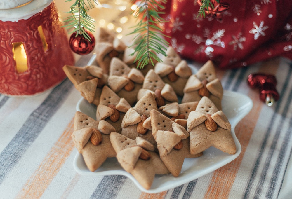 a white plate topped with cookies next to a christmas tree