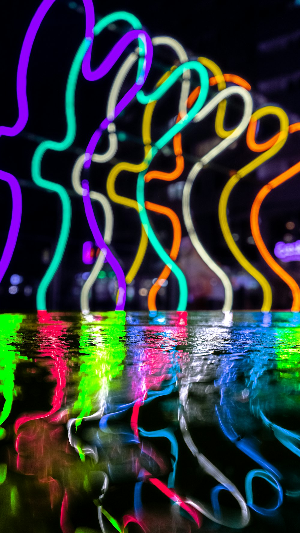 neon lights are reflected in a pool of water