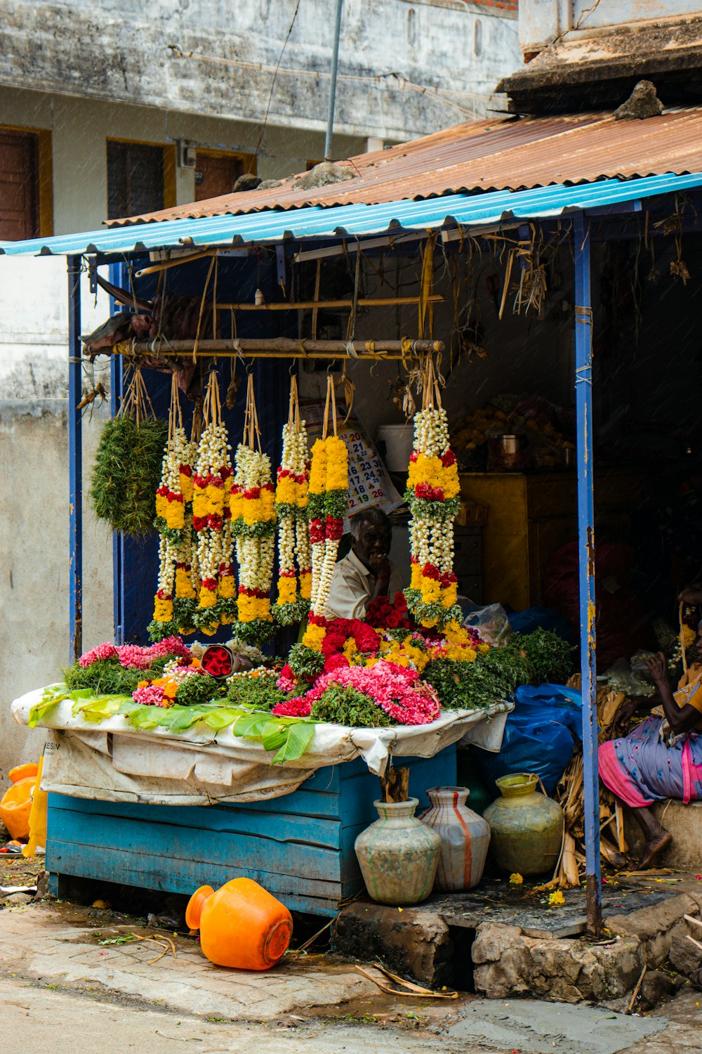 a fruit and vegetable stand on the side of the road