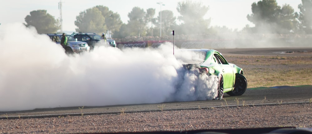 a green car with a lot of smoke coming out of it