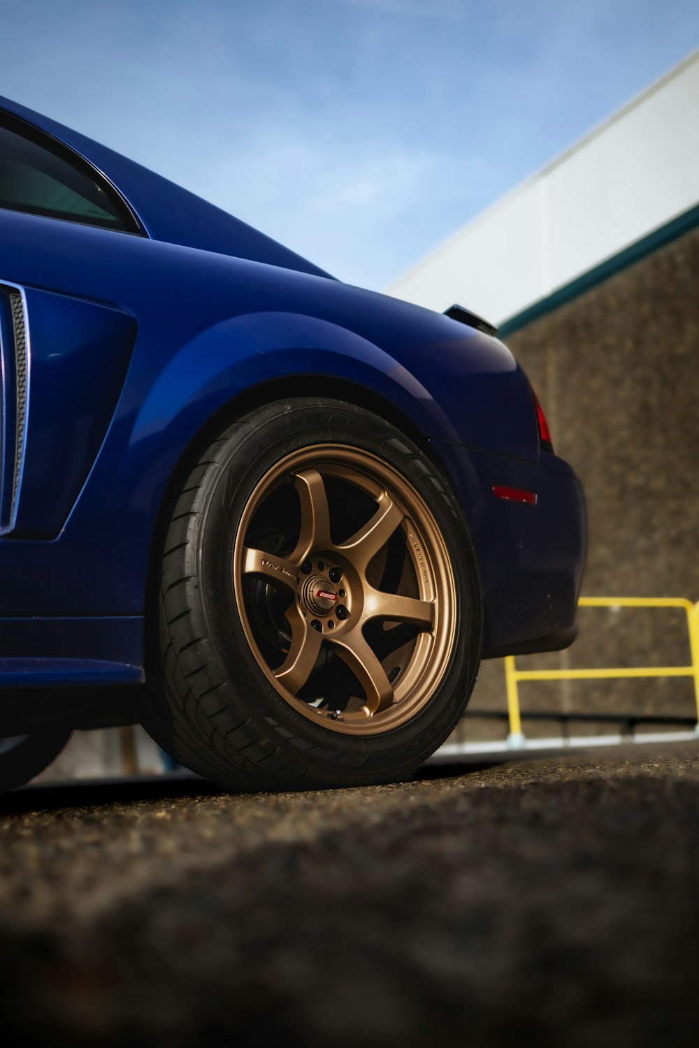 a blue sports car parked in front of a building