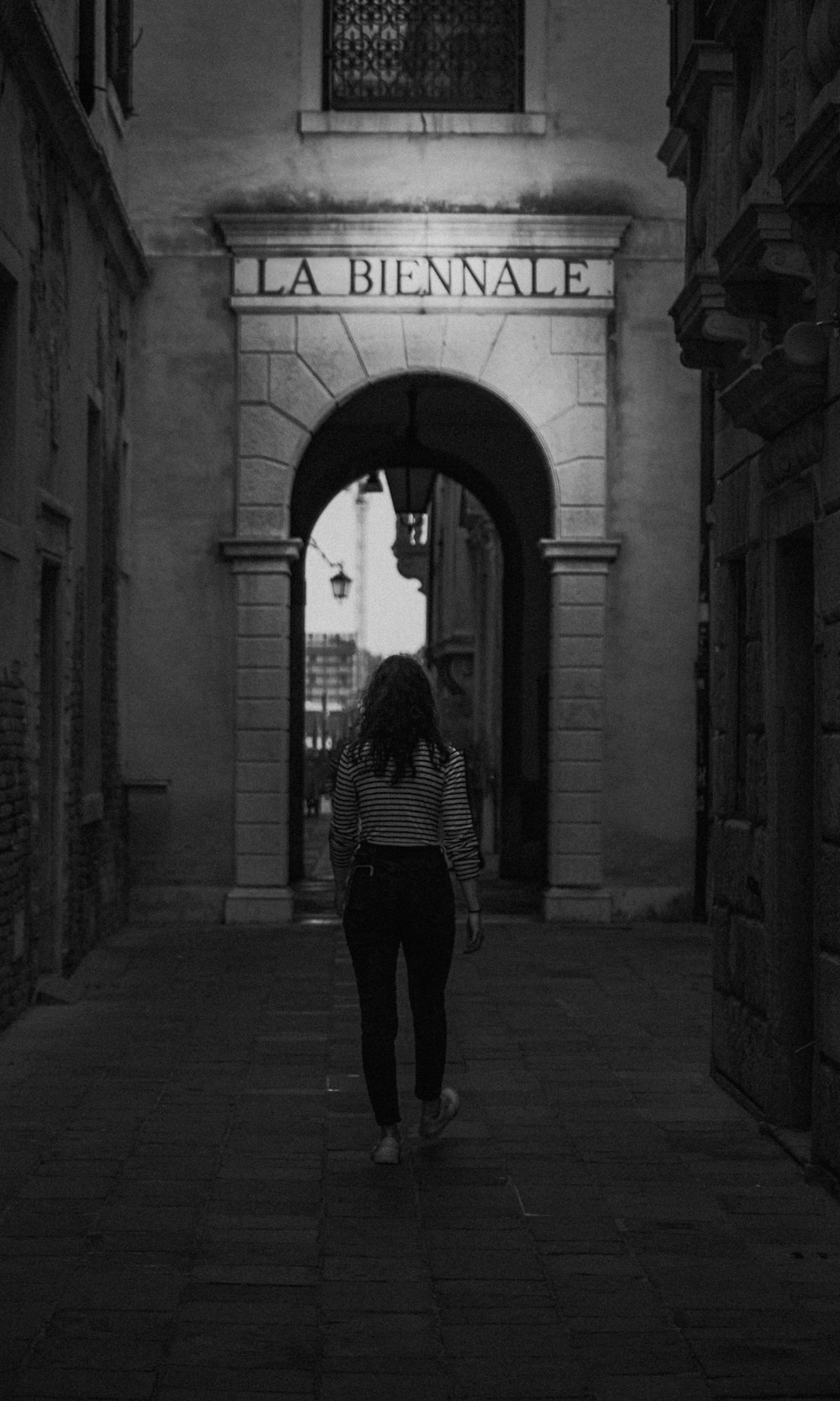 a woman walking down a dark alley way