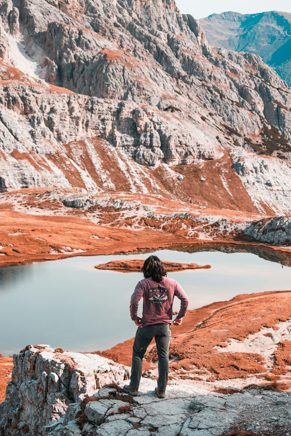 una persona de pie sobre una roca con vistas a un lago