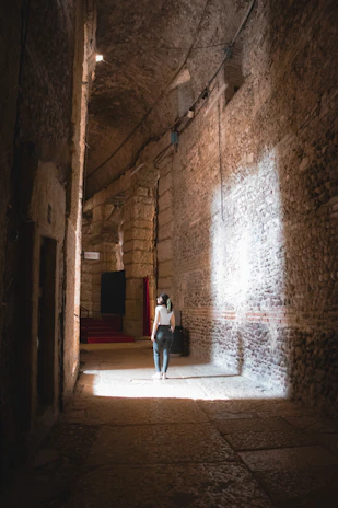 A dimly lit ancient temple corridor with subtle glowing symbols blending Guarani and Egyptian motifs on dark stone walls.