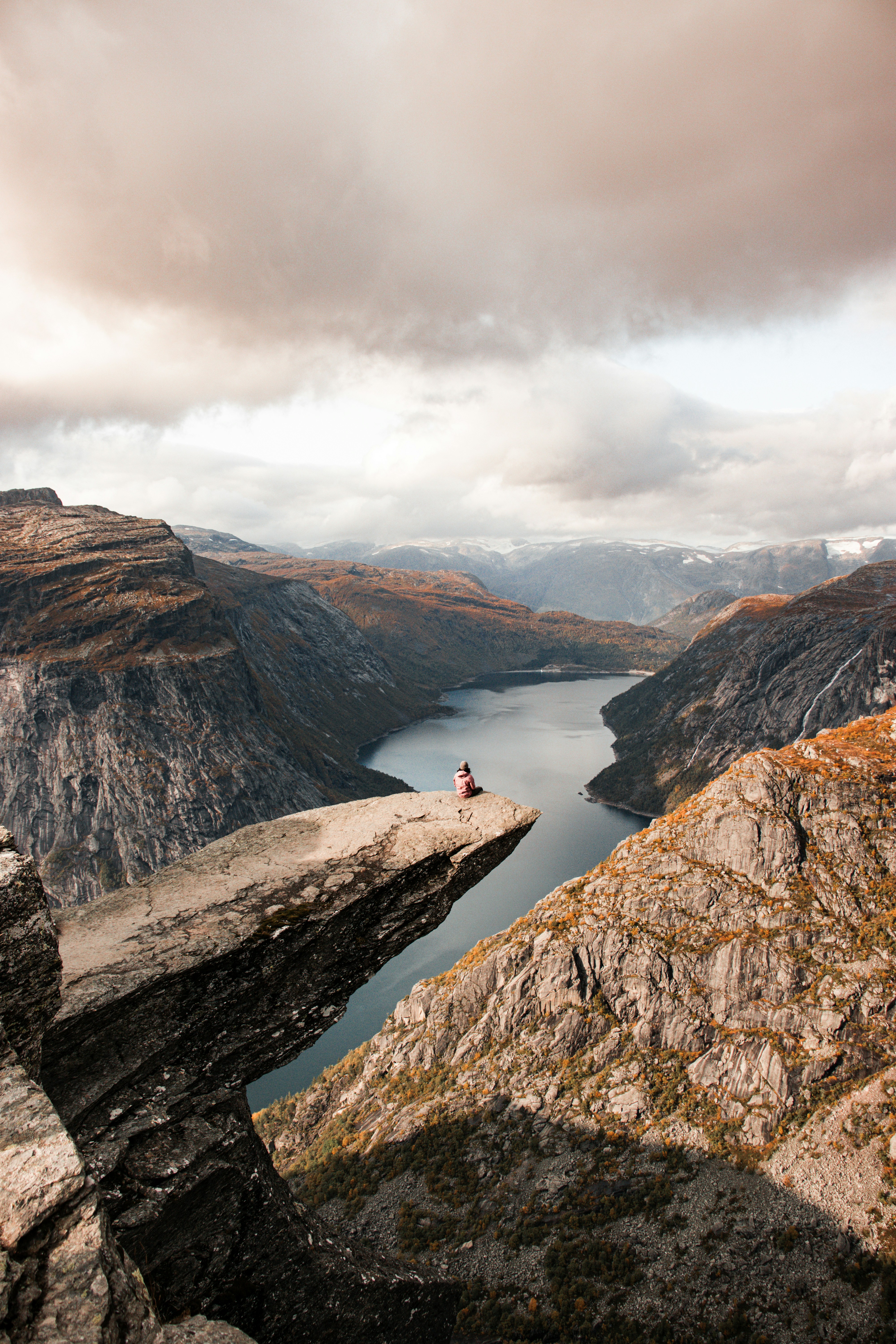 a person sitting on a rock overlooking a lake