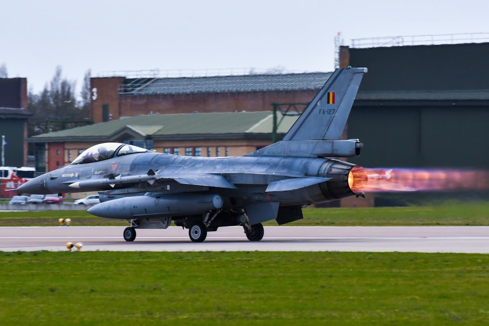 a fighter jet sitting on top of an airport runway