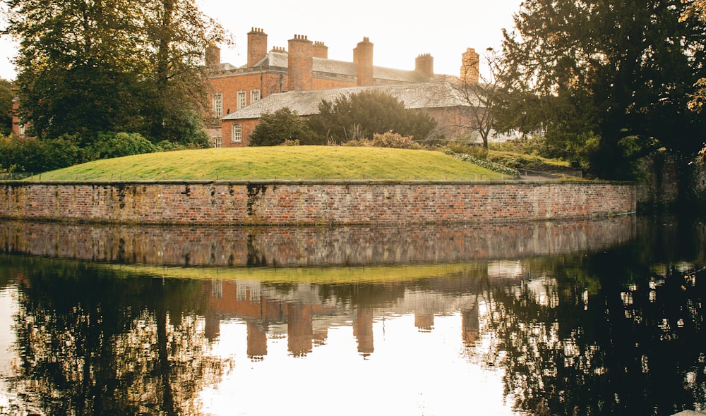 a large brick building sitting on top of a lush green hillside