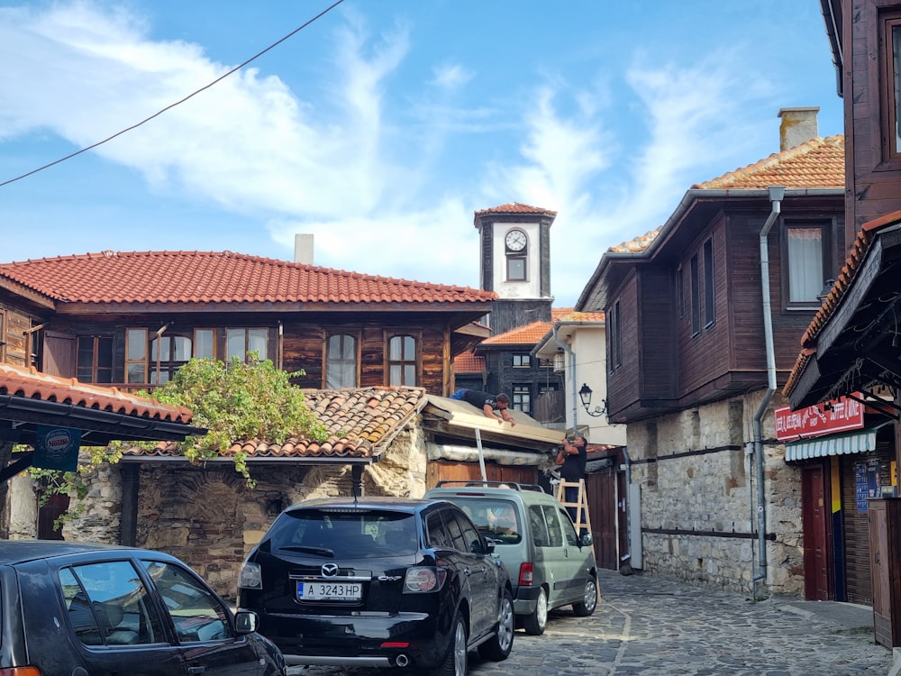 Una calle empedrada con una torre del reloj al fondo