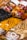 Various types of packaged pasta are displayed, featuring a mix of colors and shapes. The packages have clear labels, and the pasta includes traditional as well as colorful varieties made with different ingredients.
