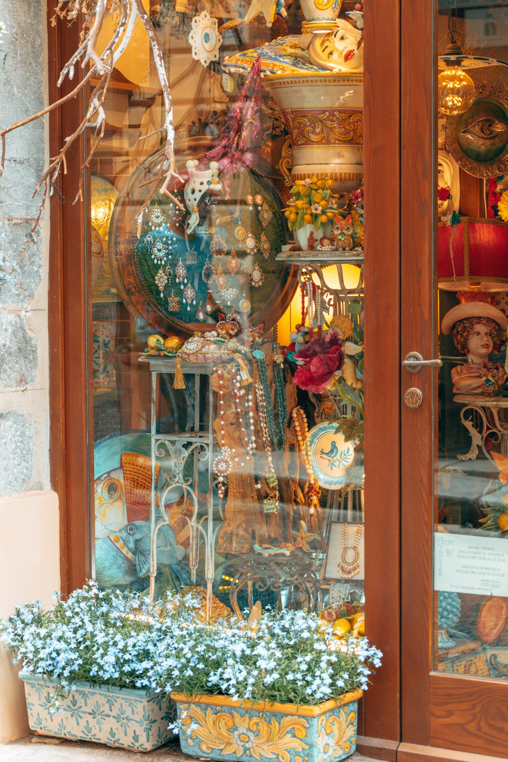 uma fachada de loja com uma exposição de vasos e outros itens