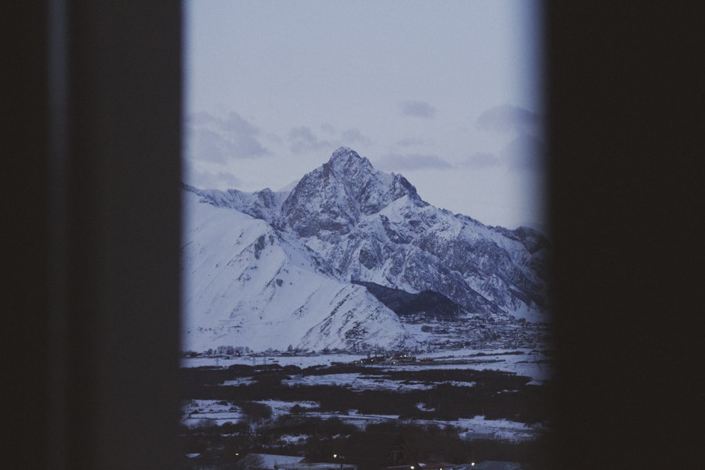 a view of a snowy mountain from a window