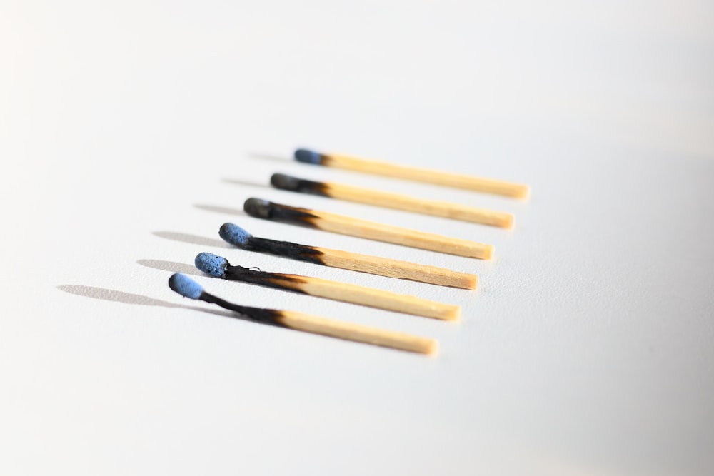 a row of matchsticks sitting on top of a white table