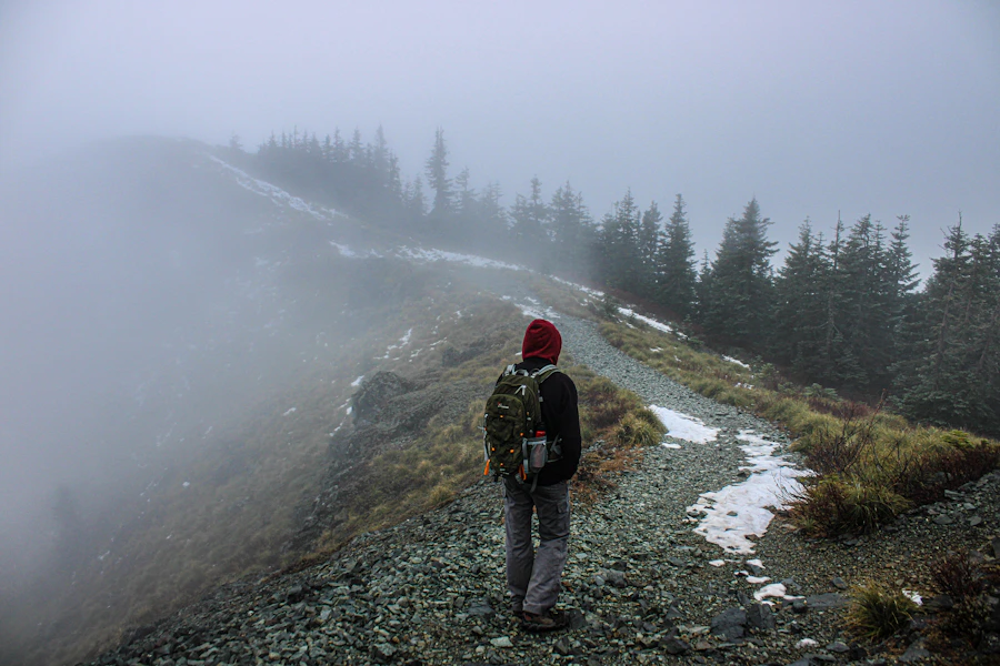 Hiker on a rocky trail in foggy alpine conditions, the Helium's intended use case