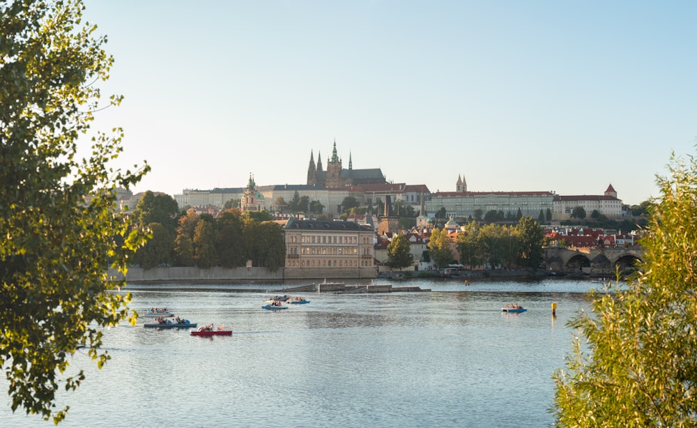 a river with boats floating on it and a city in the background