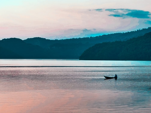 A peaceful morning scene with a boat gently floating on the calm lake.