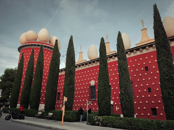 a red building with a lot of trees in front of it