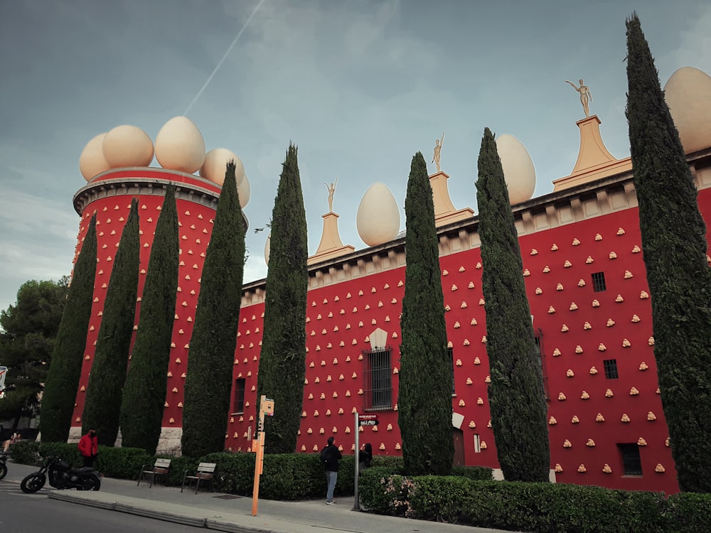 a red building with a lot of trees in front of it