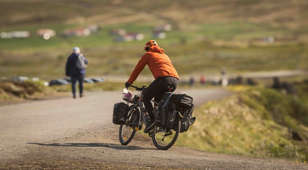 a man riding a bike down a dirt road