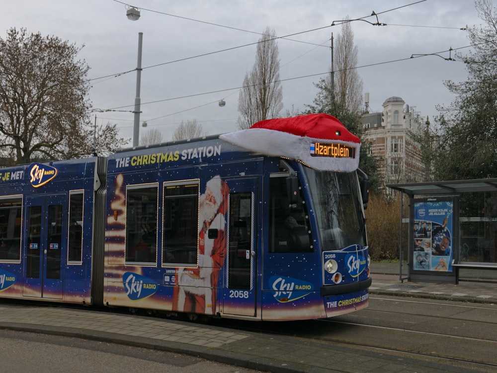 a blue train with a santa hat on top of it