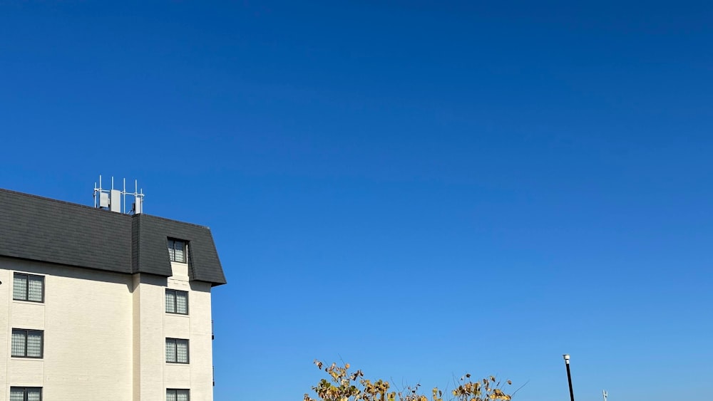 a tall white building with a black roof