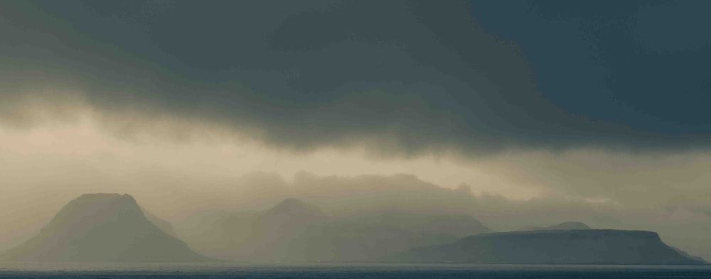 a large body of water with mountains in the background