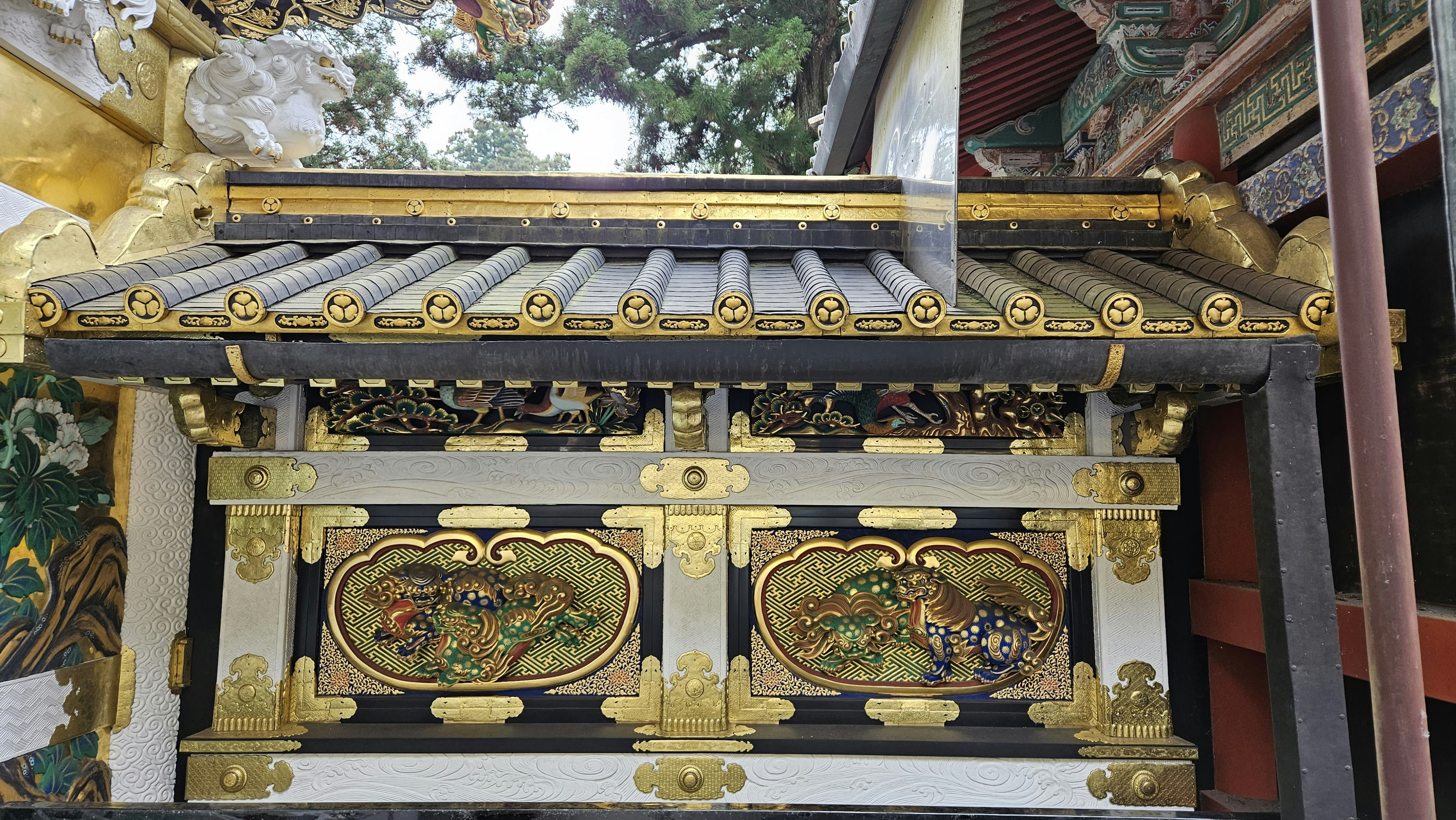 A person tossing a coin towards a large wooden saisen offering box