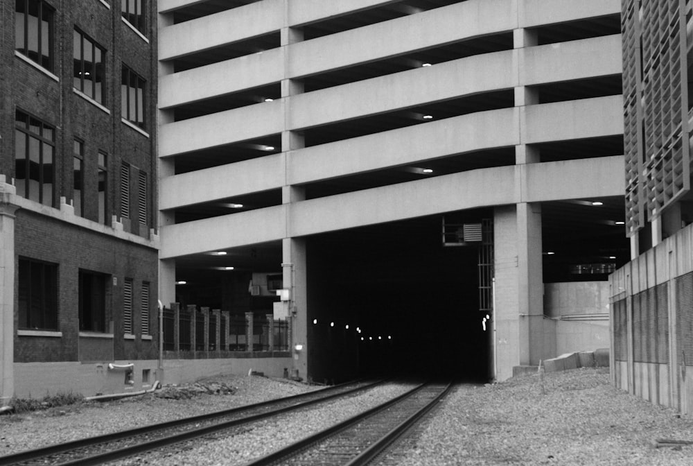 a black and white photo of a train track going into a tunnel