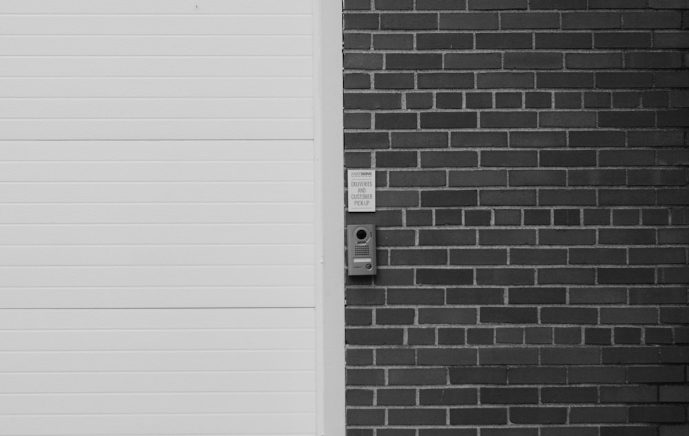 a black and white photo of a door and a brick wall
