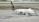 A UPS cargo airplane is parked on an airport tarmac with ground support equipment nearby. The plane is white with brown and gold detailing, featuring the logo and the words 'Worldwide Services' on its side. Several orange cones and cargo loading equipment are visible around the plane.