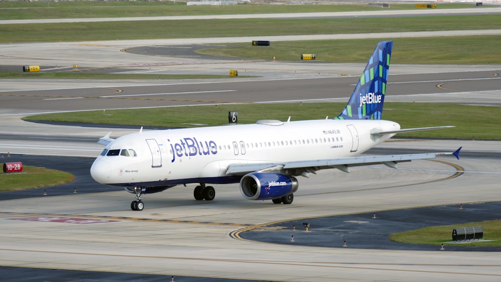 a jetblue airplane on a runway at an airport