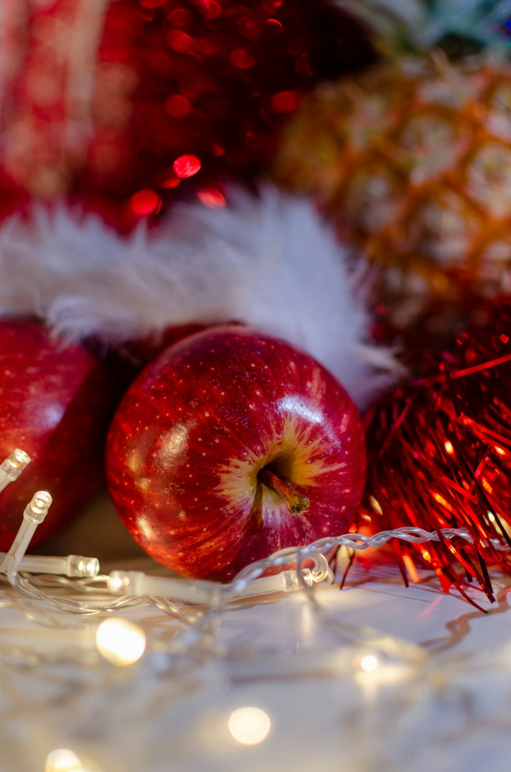 a close up of two apples near a christmas decoration