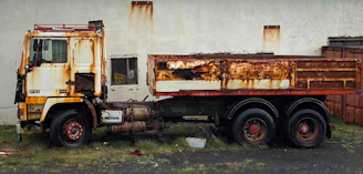 Technician applying rust repair treatment on a medium-duty truck’s body.
