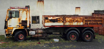 Technician applying rust repair treatment on a medium-duty truck’s body.