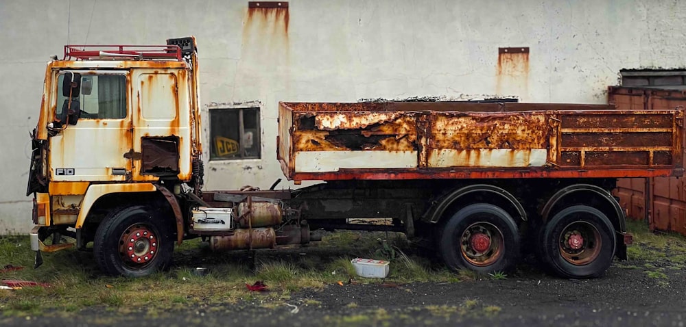 a rusted out truck parked in front of a building