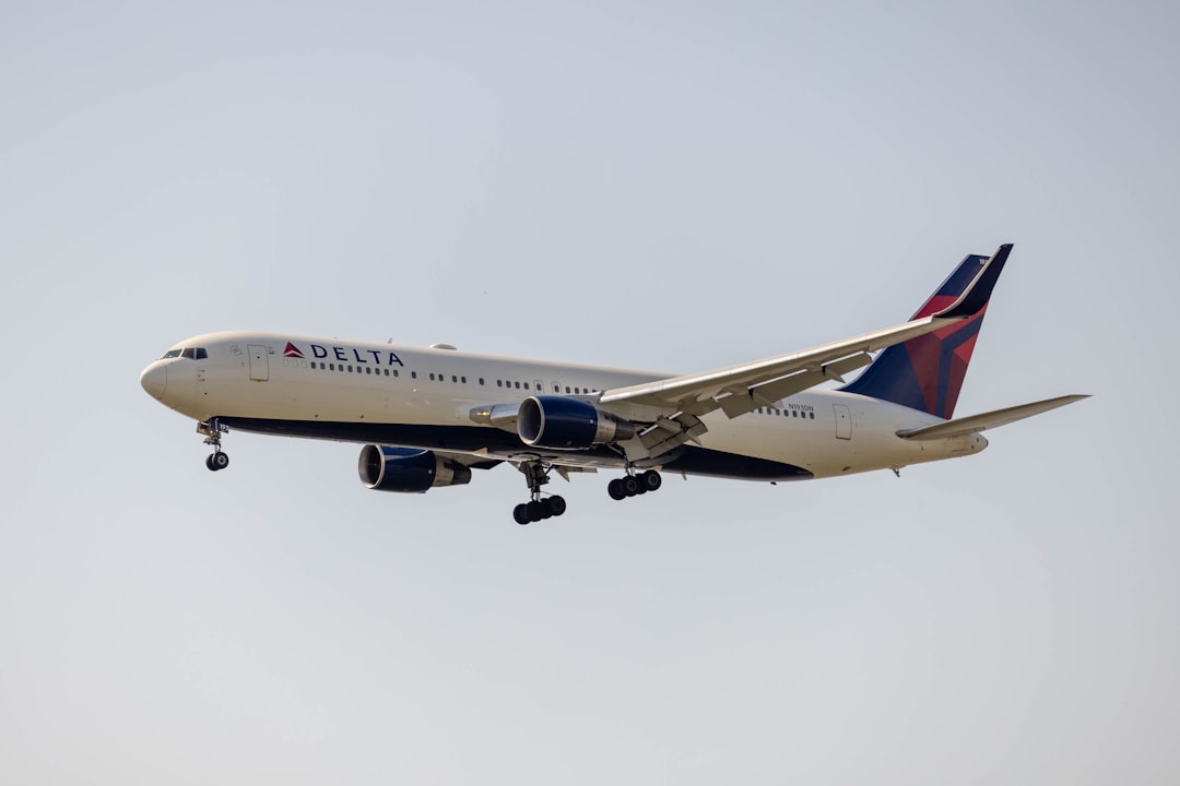 a delta airlines plane flying in the sky, Left side of a Boeing 777 by Delta Airlines in flight with landing gear pulled