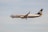 A commercial airplane flies through a clear sky. The aircraft is painted in Ryanair's blue and white livery, with the company's logo prominently visible on the tail.