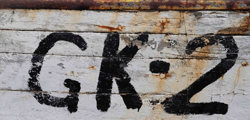 a close up of a rusted sign on the side of a building