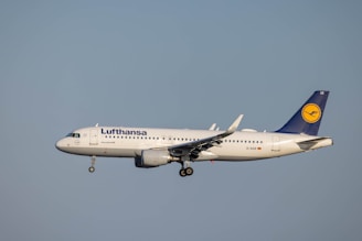 A close-up shot of a Lufthansa airplane taking off at Munich Airport during golden hour.